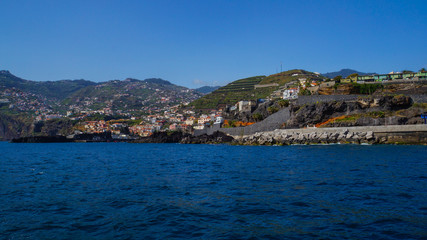 Madeira - Coast with houses and green banana plants from boat