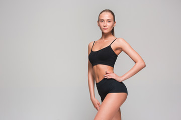 Obraz premium Muscular young woman athlete on gray