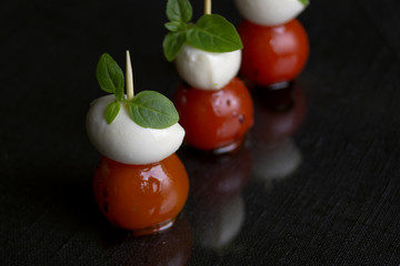 Caprese salad with ripe tomatoes and mozzarella with fresh Basil leaves. Italian food.