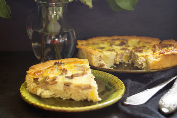 Quiche with Turkey. Homemade rustic pie on a black background.