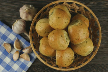 Homemade buns with garlic and dill on wooden table
