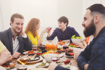 Group of happy people at festive table dinner party