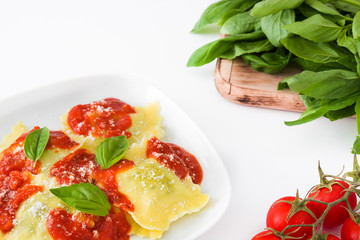 Ravioli with tomato sauce and basil isolated on white background

