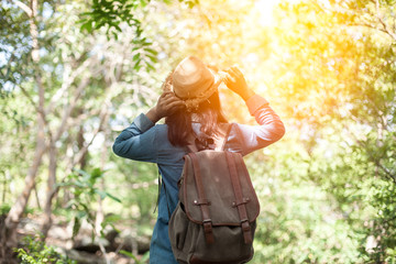 Young woman backpacker on a mountain peak cliff.
