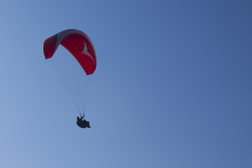 Paragliding in blue cloudy sky