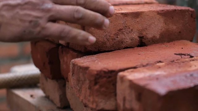 Strong man's hands building a house