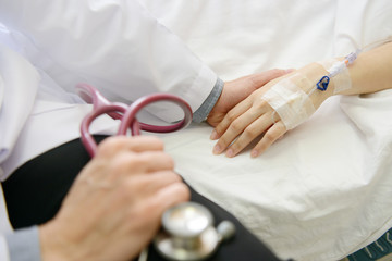 Medical doctor holing patient's hand and comforting her