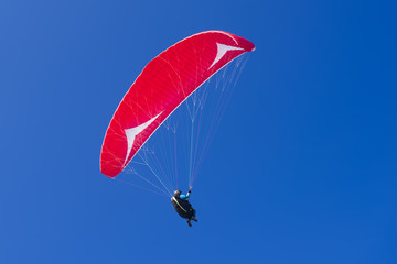 Paragliding in blue cloudy sky