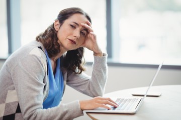 Obraz premium Portrait tired executive using laptop at desk