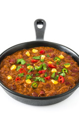 Traditional mexican tex mex chili con carne in a frying pan isolated on white background
