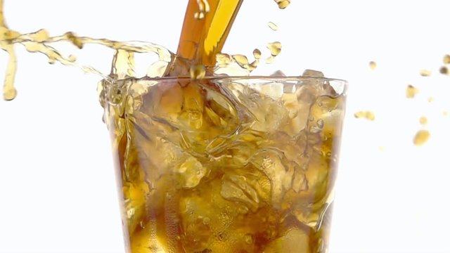 Pouring Cola into a Glass with the Ice Cubes. Slow Motion.
