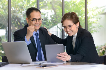 Businessman and businesswoman discussing and working together during a meeting in office
