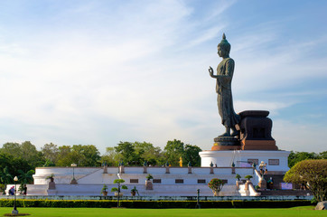 Fototapeta na wymiar buddha statue outstanding on concrete base with blue sky in buddhism park Thailand.