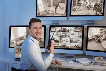 Handsome security guard in surveillance room