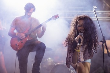 Cheeful female singer with male guitarist performing at nightclu