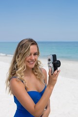 Smiling woman photographing at beach