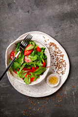 Salad with baby Spinach, arugula and Fresh Cherry Tomatoes Flax seeds and Olive oil.Food or Healthy diet concept.Super Food.Vegetarian.Top View.Copy space for Text. selective focus.