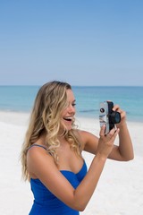 Cheerful woman photographing at beach