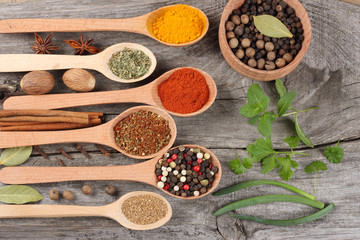 herbs and spices, onion, garlic and chili pepper on old wooden background. Top view