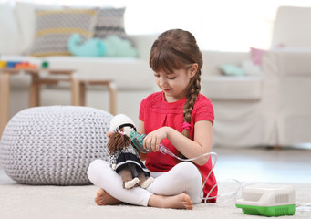 Cute little girl playing with nebulizer at home. Allergy concept