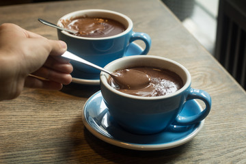 Blue Cups of hot Chocolate drink on dark wooden background. Morning time. Lover concept