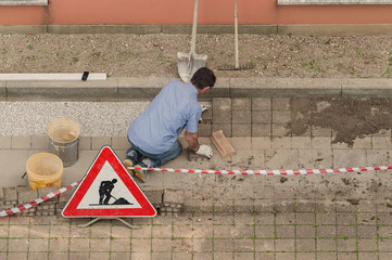 Bricklayer at work laying stone blocks.
