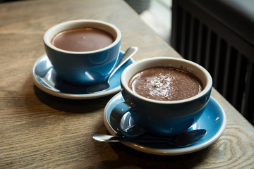 Blue Cups of hot Chocolate drink on dark wooden background. Morning time. Lover concept