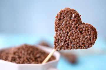 Heart shaped crispy dessert in cup on blue background