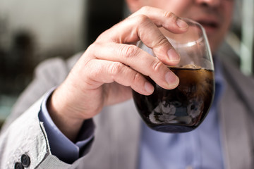 Glass of Cola Soda With Ice in Male Hand