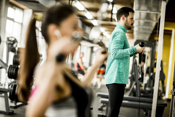 Young couple exercise bodybuilding exercises in the gym