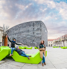 Fototapeta premium Group of friends having fun and sitting on the bench at park in Vienna