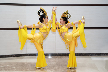 wo beautiful girl actress in yellow traditional chinese stage costumes standing in acrobatic pose...