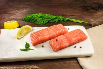 Two slices of salmon on dark background with copyspace