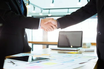 Successful businessmen handshaking after good deal.