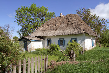 The old clay house under the thatched roof is destroyed among the bright young spring life. Young shoots come to replace the old foundations.