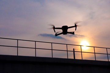 drone quadcopter flying at sunset