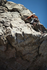 A rock climber climbs the wall in the mountains. © esalienko