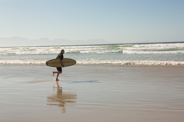 Man with surfboard walking on shore