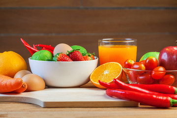 Healthy concept with mixed fruits and vegetables on wooden background