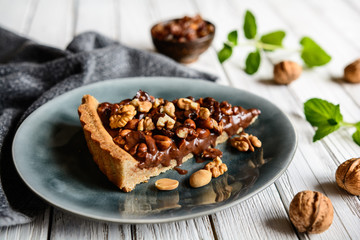 Delicious chocolate tart with walnut, peanut, dried cranberry and raisins