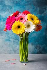 Colorful bunch of gerbera flowers in a glass vase.