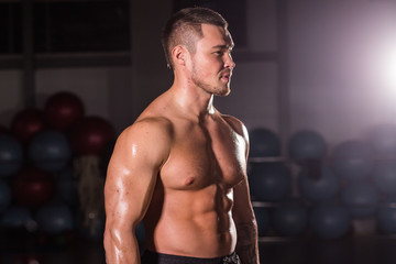 Fototapeta na wymiar Young handsome muscular man bodybuilder posing in gym