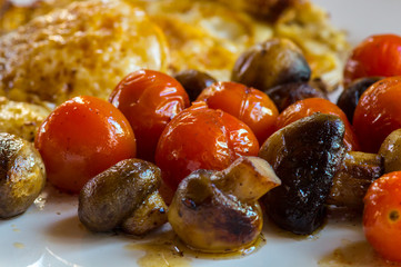 Muschrooms tomatoes and egg on a white plate
