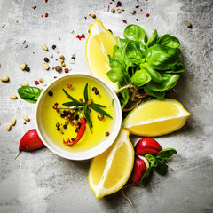 Salad dressing with basil, olive oil, garlic, lemon and spices, top view, food background