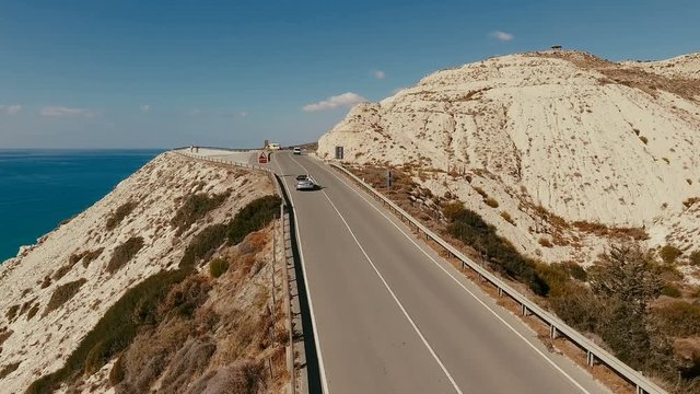 The cabriolet with girl moves on the road between mountains
