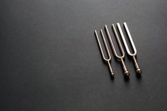 Three tuning forks on a black background