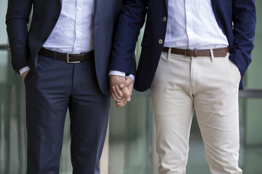 two men in suits holding hands