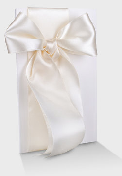 postcard white designer cardboard tabby with white satin bow wedding invitation on a light cloth grey background