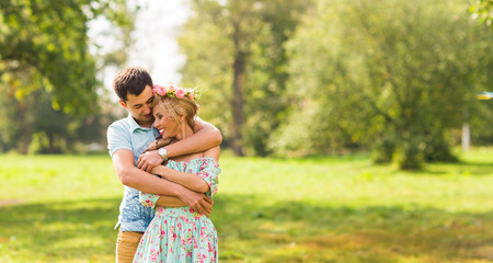 Couple embracing on the countryside. Young romantic man and woman standing and hugging each other with tenderness on nature. Young love concept.