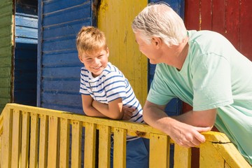 Close up of happy grandfather and grandson leaning on railing